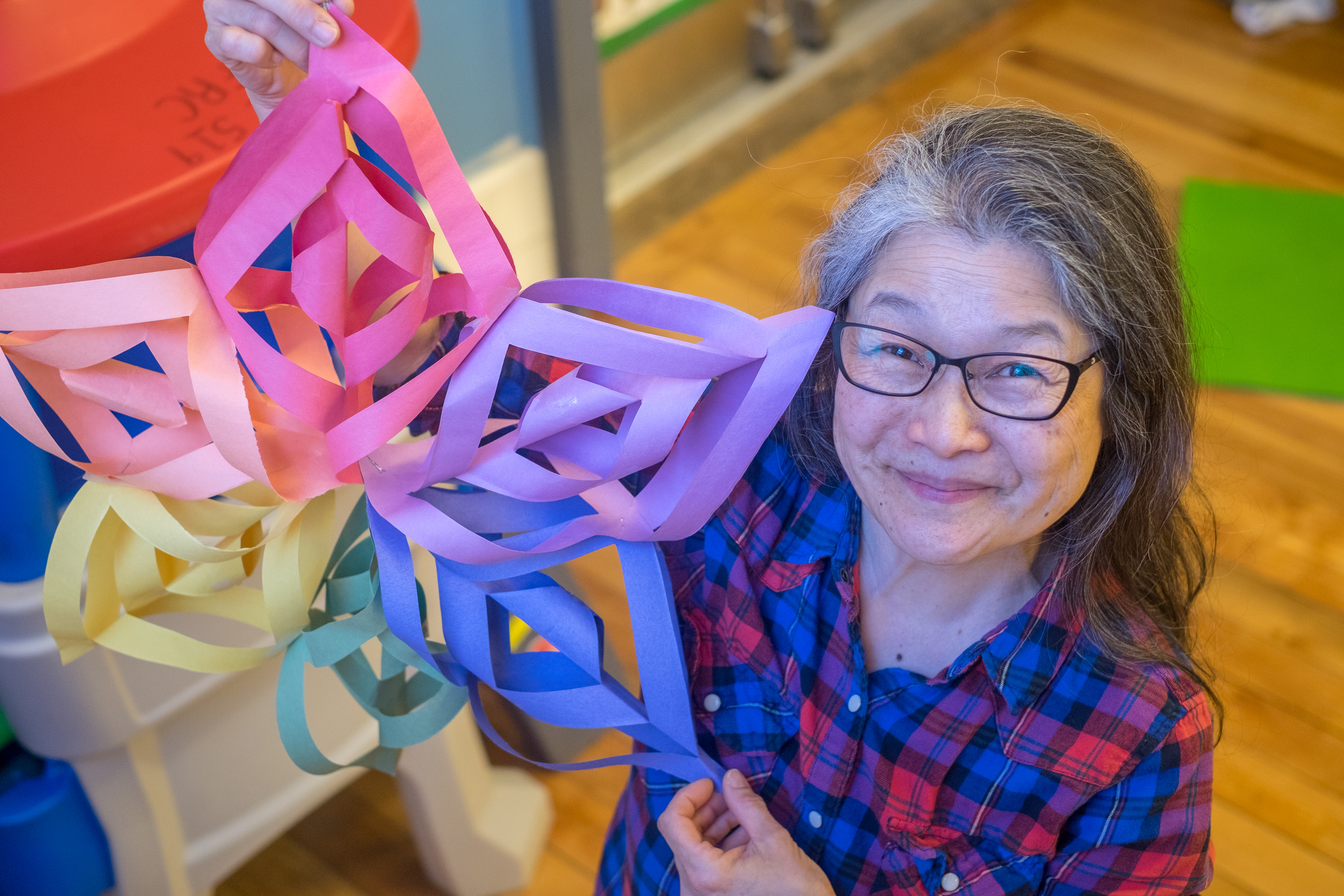 Portrait of Joanne holding an artwork she made.